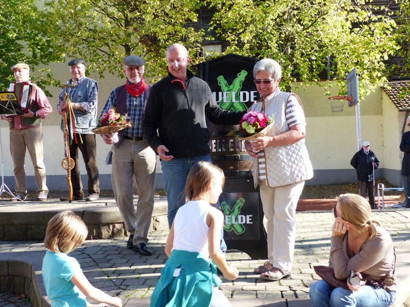 Dieter Burkhard vom Heimat- und Kulturkreis übergibt Blumen an hilfreiche Hände.