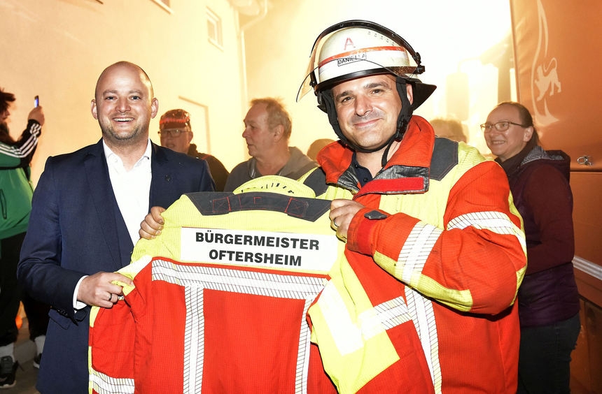 Aus den Händen von Feuerwehrkommandant Andrea Danieli erhält der neue Rathauschef eine eigens für ihn bedruckte Einsatzjacke mit Bürgermeister-Rückenschild.