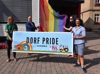  Die Regenbogenflagge wird wegen der Dorfpride-Demonstration am Rathaus gehisst. Von links nach rechts: Patrick Alberti, Bürgermeister Jens Geiß, Johannah Illgner, Sarah Kinzebach