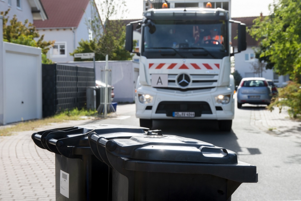 Müllauto vor Mülltonnen, Foto: AVR Kommunal AöR