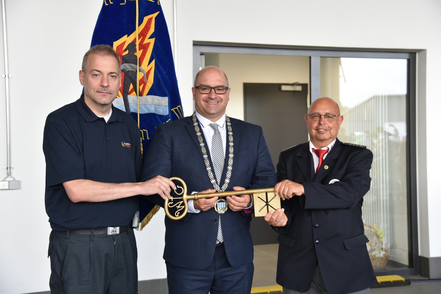 Bürgermeister Geiß übergibt den symbolischen Schlüssel an den Feuerwehrkommandanten Rüdiger Laser und den DRK-Ortsvereinsvorsitzende Hans-Thomas Dilger.