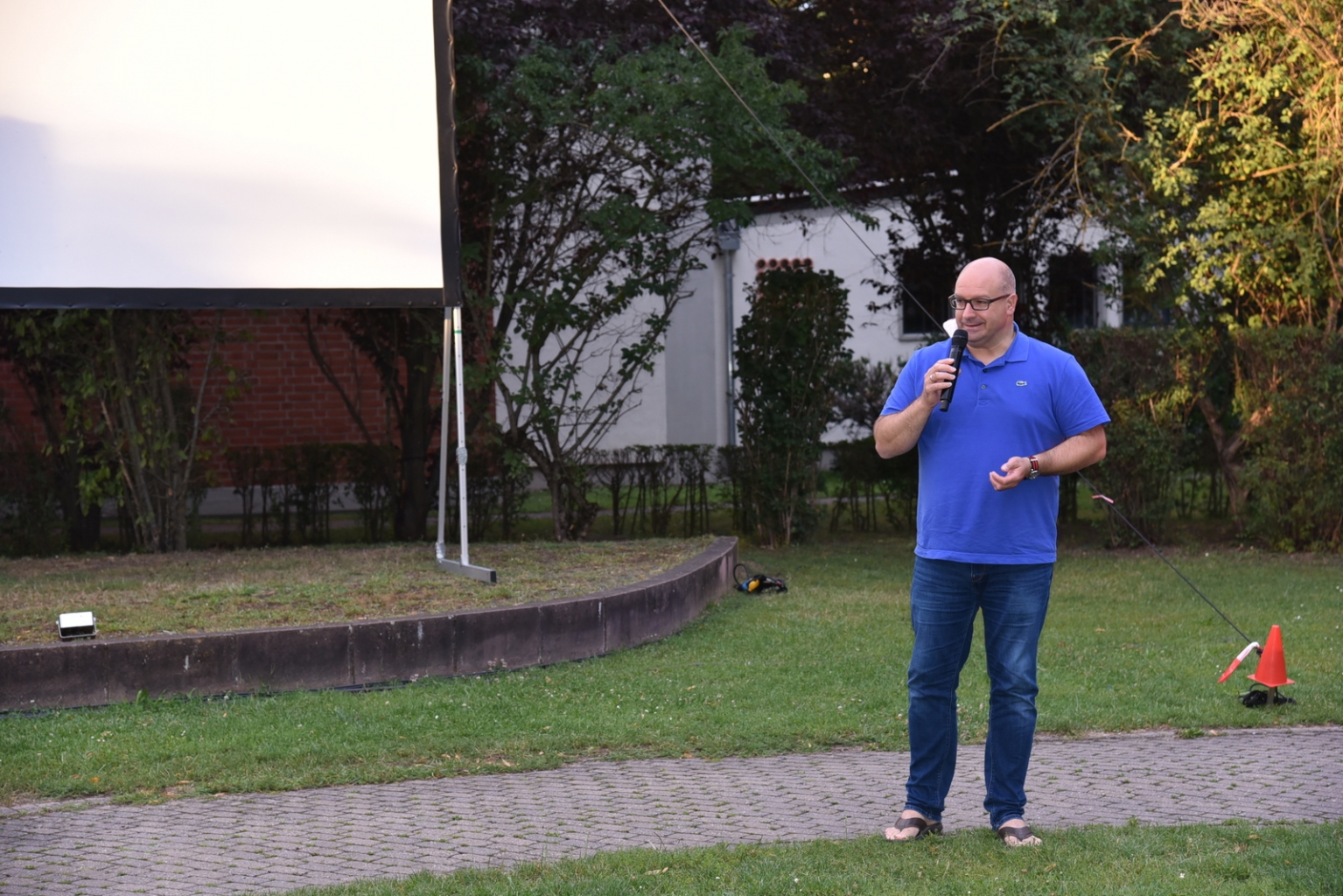 Bürgermeister Jens Geiß begrüßt die Besucher*innen im Gemeindepark zum Open Air Kino.