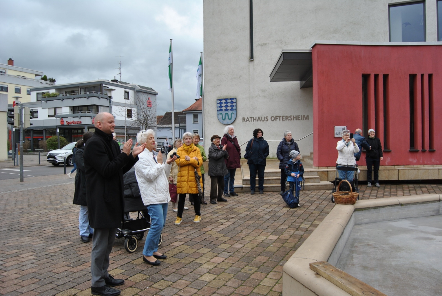 Neben Bürgermeister Pascal Seidel (v. l.) sind auch einige Bürgerinnen und Bürger zur Aufstellung der Osterkrone gekommen. Foto: Gemeinde