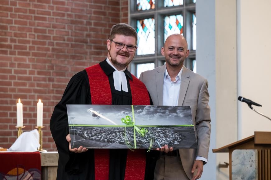 Bürgermeister Pascal Seidel überreicht Pfarrer Tobias Habicht ein Abschiedsgeschenk. Bild: Ralf Lackner Bürgermeister Pascal Seidel überreicht Pfarrer Tobias Habicht ein Abschiedsgeschenk. Bild: Ralf Lackner