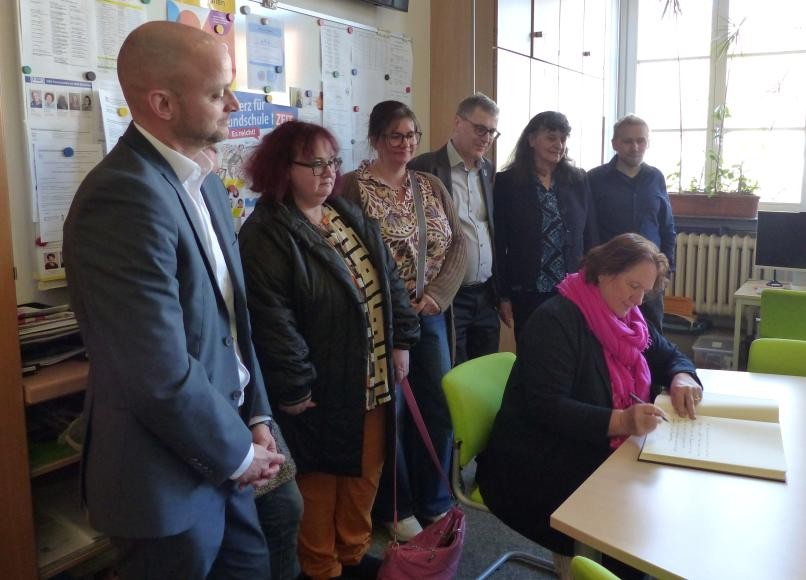 Kultusministerin Theresa Schopper trägt sich ins Goldene Buch ein.