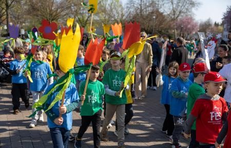 Kinder tragen riesige Papiertulpen