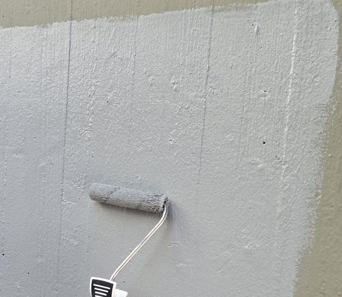 Farbroller an der Betonwand