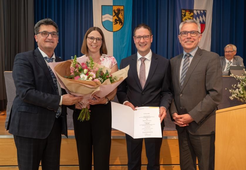 (Quelle: Landratsamt Rhein-Neckar-Kreis)  Der 1. stellvertretende Vorsitzende des Kreistags, Frank Werner (links) überreichte dem neuen Landrat Manuel Just (2. v. r.) seine Ernennungsurkunde und dessen Gattin Stefanie Just einen Blumenstrauß. Just übernahm am 1. Mai die Amtsgeschäfte des scheidenden Landrats Stefan Dallinger.