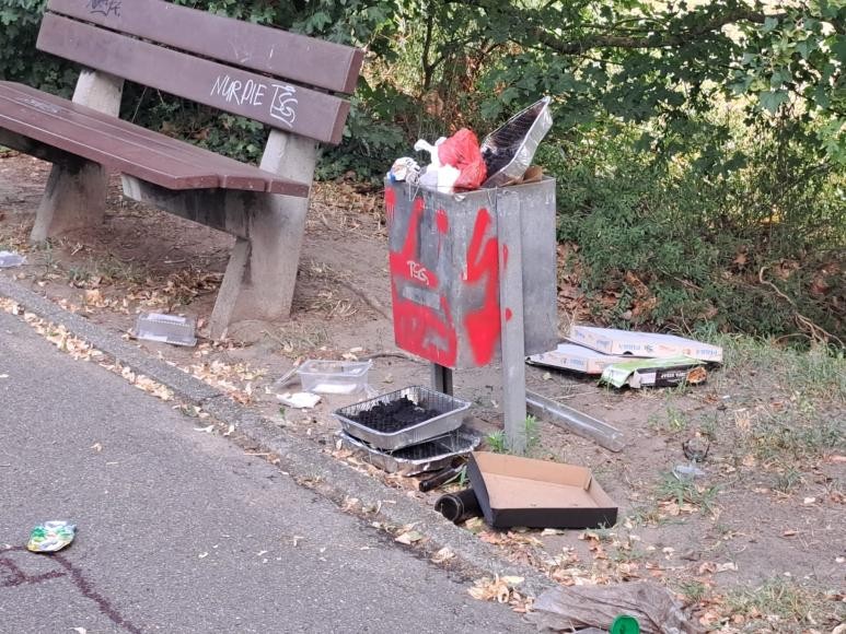 Einweggrills neben Sitzbank auf dem Jugendplatz. Die Bank brannte schon einmal